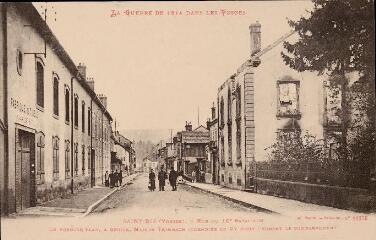 La Guerre de 1914 dans les Vosges. Saint-Dié (Vosges). - Rue du 10e bataillon. En premier plan, à droite, Maison Trimbach incendiée le 27 août pendant le bombardement.