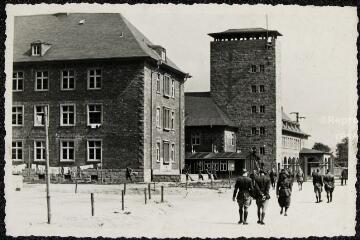 Prisonniers de guerre à l’entrée du camp et vue des bâtiments du camp.