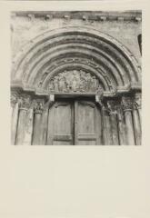 Saint-Ursanne - collégiale. – Vue rapprochée sur le portail et le fronton ; tympan avec le Christ entouré de saints Paul et Pierre.
