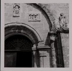 Martinvelle - église Saint-Pierre-aux-Liens. – Détail du portail ; fronton avec des bas-reliefs représentant saintes Anne, Marguerite et Barbe, ainsi que le Calvaire.