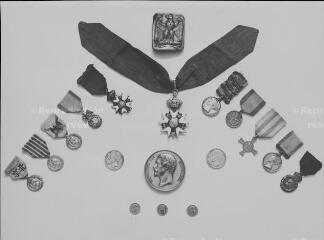 Médailles militaires, croix de la Légion d'honneur et pièces de monnaie.