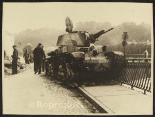 1 vue  - Campagne de France.– Vue d\'un char allemand Pz 35(t) détruit sur le quai Boyé. À l\'arrière-plan, des hommes participent au déblaiement de la rue. (ouvre la visionneuse)